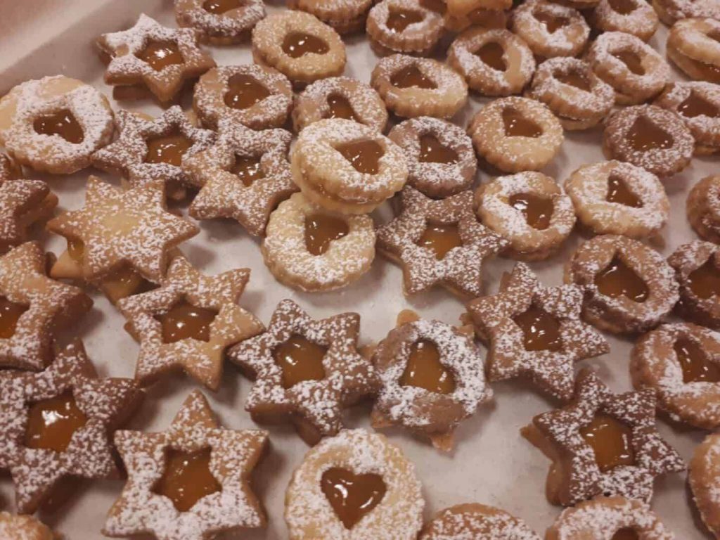 Linzer Augen in verschiedenen Formen, mit Marmelade gefüllt und Puderzucker bestreut.