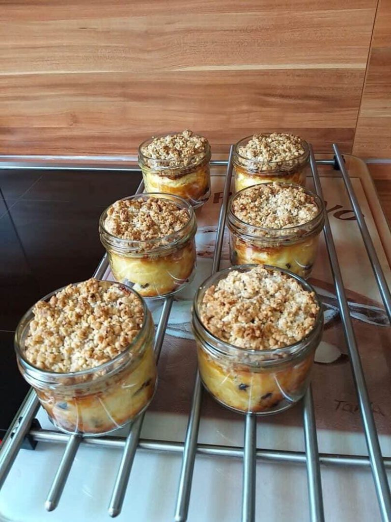 Cheesecakes mit Streuseln in Gläsern auf einem Abkühlgitter.